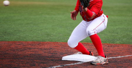 Ball thrown from the outfied to the third baseman to tag out the runner during a high school baseball game.の写真素材