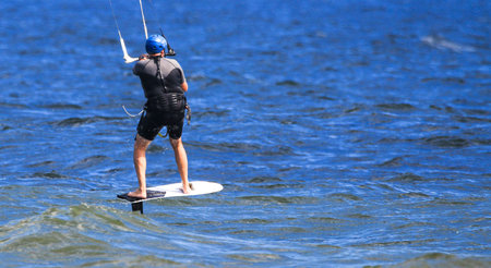 One man kitesurfing wearing a wetsuit off the coast of Long Island New York.