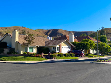 A street with houses and a car parked on the side of the road.のeditorial素材