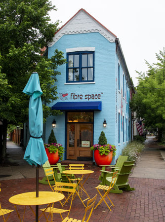 Alexandria, Virginia, USA - 23 June 2023: A blue building with tables and chairs outside of it