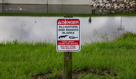 A sign warning of alligators and snakes in area by a stream in Florida USA.の写真素材
