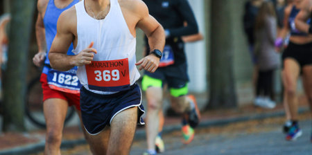 Runners on the road wearing race bibs during a marathon.