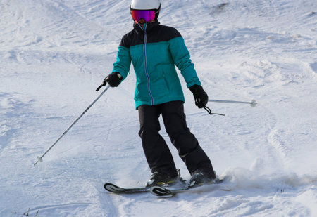 One female skier skiing with confidence down a mountain close up.の写真素材