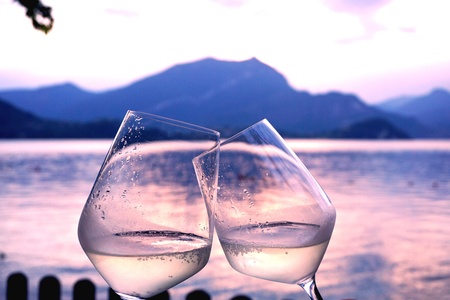 Two glasses of champagne toasting by a lakeの素材