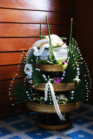 Rice offering in the wedding ceremony northern in Thailand,  Twist the white thread with wrist tie, Background wood and shadows, Made with green banana leafの写真素材