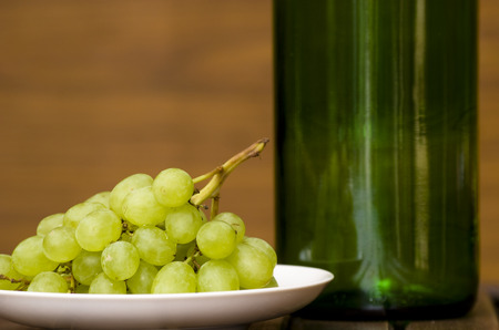 Still life with bottle and grape on plateの写真素材