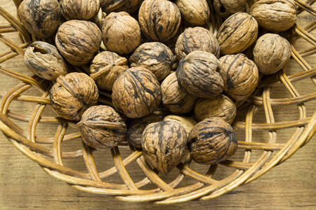 Walnuts in basket on wood table in detailの写真素材