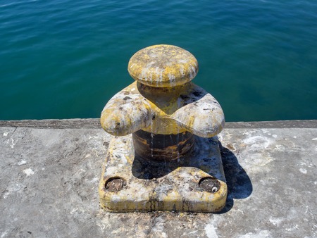 Yellow boat bollard covered in seagull droppings at the harbour of Lambert's Bay, South Africa.の写真素材