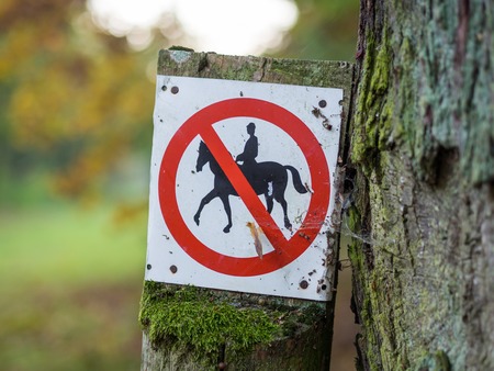 Horse riding prohibited or forbidden sign in black, white, red in forest near Berlin, Germanyの写真素材