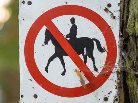 Horse riding prohibited or forbidden sign in black, white, red in forest near Berlin, Germanyの写真素材