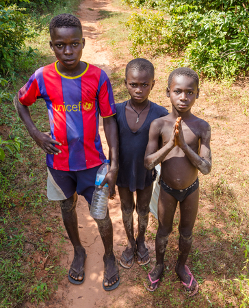 Bubaque, Guinea Bissau - December 09, 2013: Portrait of tthree unidentified young African boys on dirt pathのeditorial素材