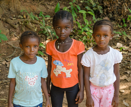 Bubaque, Guinea Bissau - December 09, 2013: Portrait of tthree unidentified young African girls on dirt pathのeditorial素材