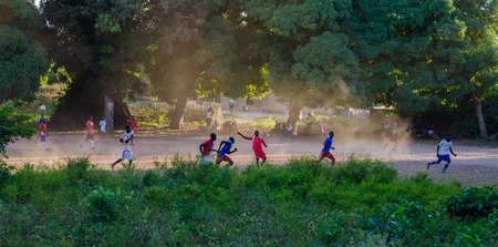 Bubaque, Guinea Bissau - December 11, 2013: Unidentified group of men playing football or soccer on dirt fieldのeditorial素材
