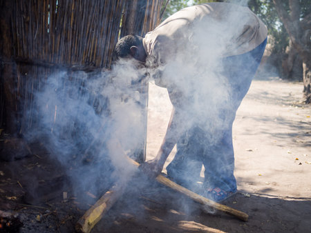 Luzibalule, Namibia - August 13, 2015: Unidentified African man operating traditional forge at...