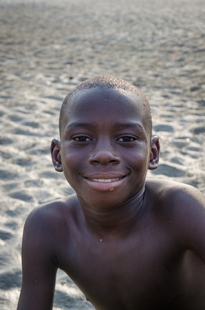 Tokeh Beach, Sierra Leone - January 05, 2014: Portrait of unidentified young African boy smiling at mangrove beachのeditorial素材