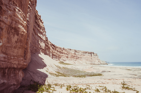Towering red sandstone cliffs at Angolas coast line in the Namib Desertの写真素材