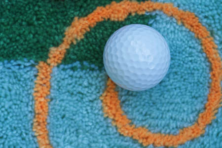 Dimples on white golf ball surface, carpet backgroundの写真素材