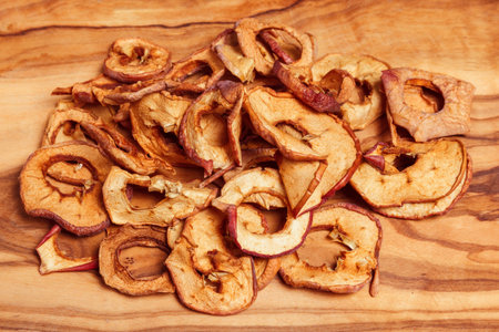 Dried fruits, apples, pear on wood background