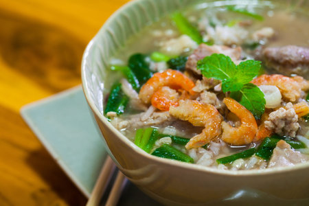 a bowl of boiled brown rice with pork and dried shrimp.