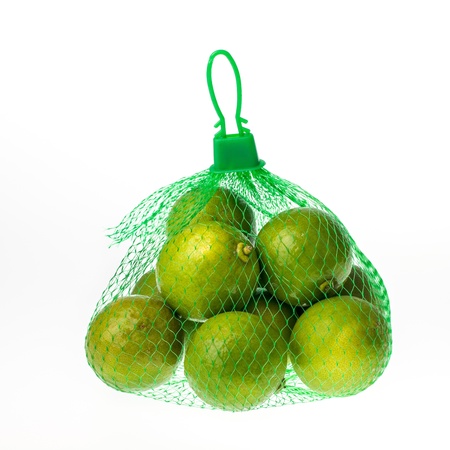 Lemons in the green net on the white isolated backgroundの写真素材