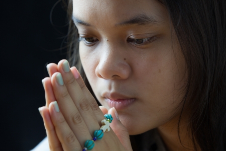 Young woman was holding blue rosary in handsの写真素材