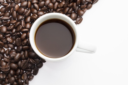 Top view of a cup of hot coffee on coffee beans backgroundの写真素材