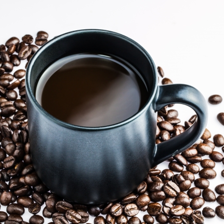 Top view of a cup of hot coffee on coffee beans backgroundの写真素材