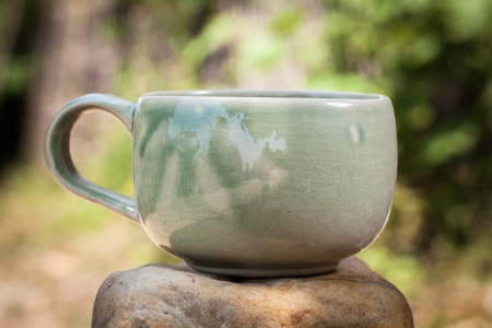 Green tea cup in the garden place on the rockの写真素材