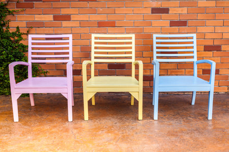 Wooden chairs in the garden in front of bricks backgroundの写真素材