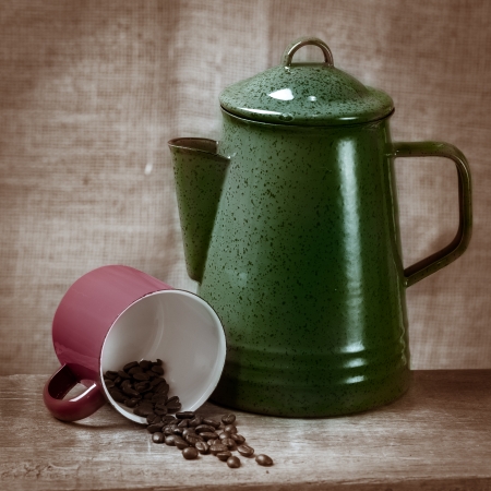 Green tea pot with red cup and coffee beans on the wooden tableの写真素材