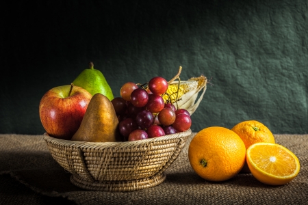 Still life fruits, fresh fruit display in wooden basket and some place on sack clothの写真素材