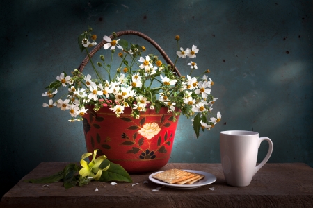 red basket with white flower, coffee cup and biscuits on wooden tableの写真素材