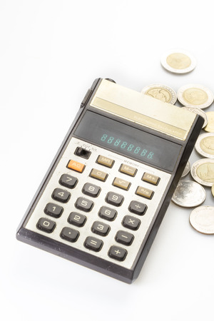 Old calculator and coins, isolated on whiteの写真素材