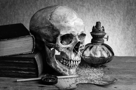Still life, human skull with compass on torn map and ancient lanternの写真素材