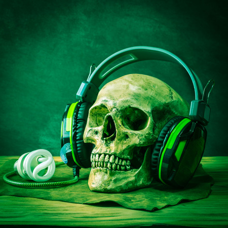 Still life with human skull wearing headphonesの写真素材