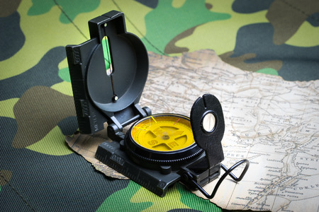 Military compass and map on a camouflage backgroundの写真素材