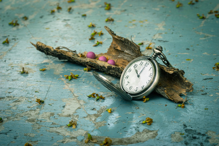 Vintage pocket watch on rusty metal table with dry woodの写真素材