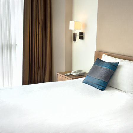 Modern bedroom with white bed sheetの写真素材
