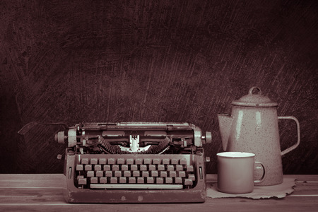 Still life, old typewriter and vintage teapot on wooden deskの写真素材