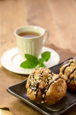 Tasty eclairs on table with tea cupの写真素材