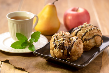 Tasty eclairs on table with tea cupの写真素材