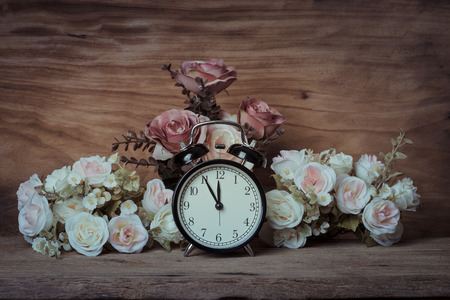 still life, vintage alarm clock with flowers on wooden tableの写真素材