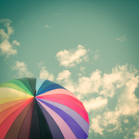 Rainbow umbrella on sky background, vintage styleの写真素材