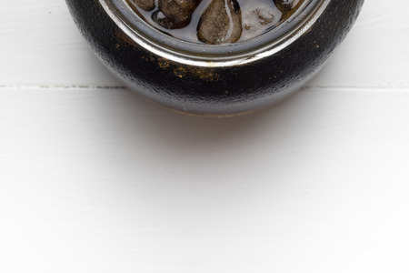 Cola in glass with ice from top on white background with space for textの写真素材