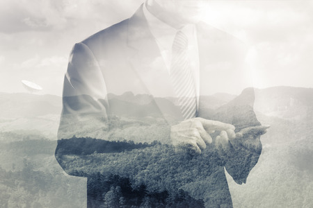 Double exposure of satellite dish on the hill and business man using smart phoneの写真素材