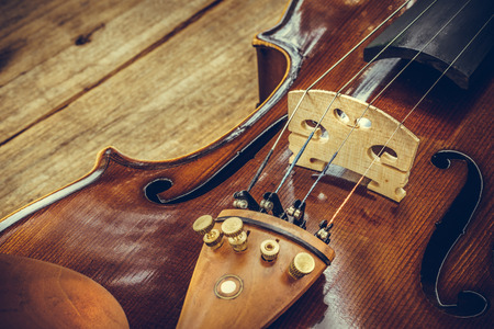 Art. Closeup of old wooden violin stringed instrument on old wooden table. Classical music.の写真素材