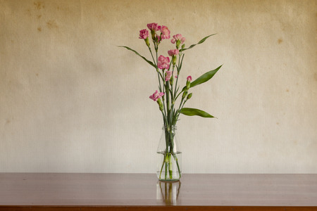 Still life with flowers in glass bottle on wooden tableの写真素材