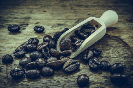 Coffee beans in wooden scoopの写真素材