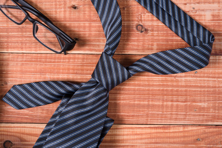 Stripe neck tie and glasses on old wooden tableの写真素材