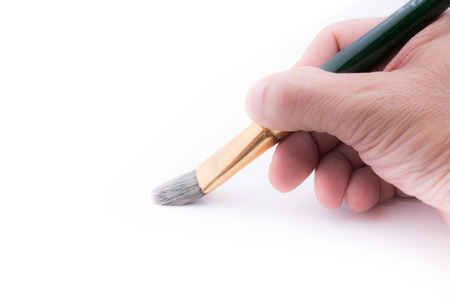 paint brush in human hand on white backgroundの写真素材